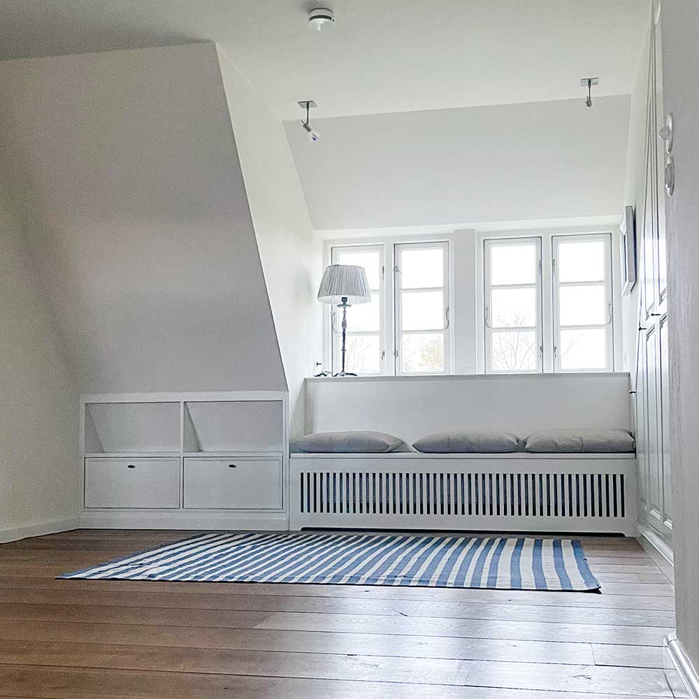 Luxus Ferienhaus auf der Nordseeinsel Föhr: Lichtdurchfluteter Flurbereich im Obergeschoss mit Bank